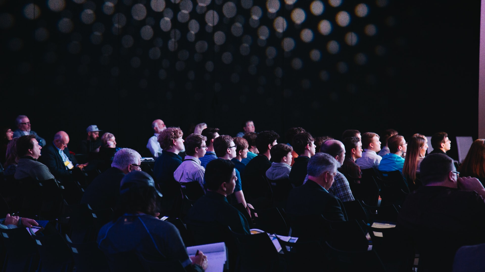 crowd of people sitting on chairs inside room